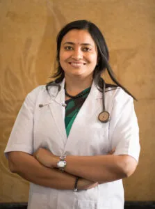 Dr. Parul Gupta, a professional doctor at Jain Surgical Hospital in Kota, wearing a white coat and green shirt.