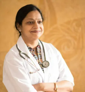 A professional doctor, Dr. Payal Rastogi, wearing a white coat and stethoscope at Jain Surgical Hospital in Kota.