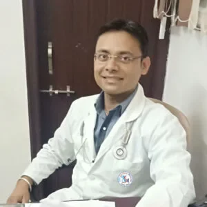 A professional doctor, Dr. Amit Gupta, sits at his desk with a laptop at Jain Surgical Hospital, a top hospital in Kota.