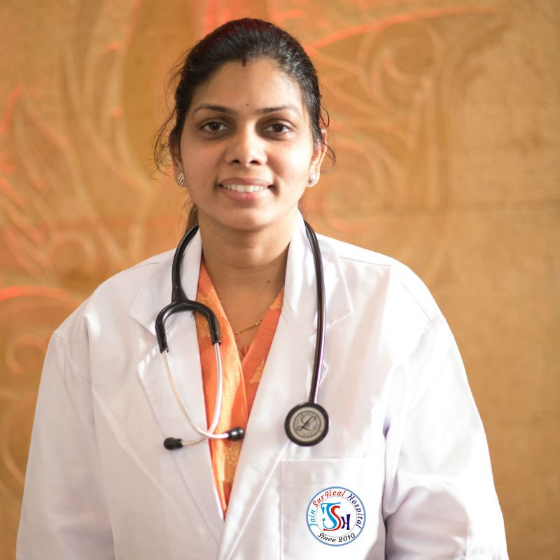 A woman in a white coat and orange shirt, Dr. Neetu Agrawal, at Kota's best hospital.