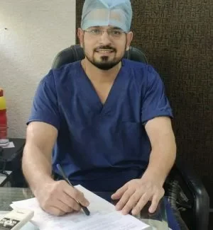Vishwas sharma A man in scrubs sits at a desk with papers, working at Jain Surgical Hospital, the top hospital in Kota.